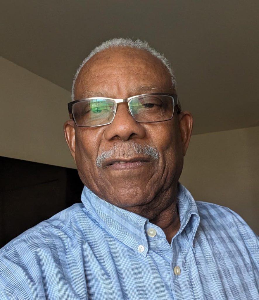 Man in glasses wearing blue check shirt.